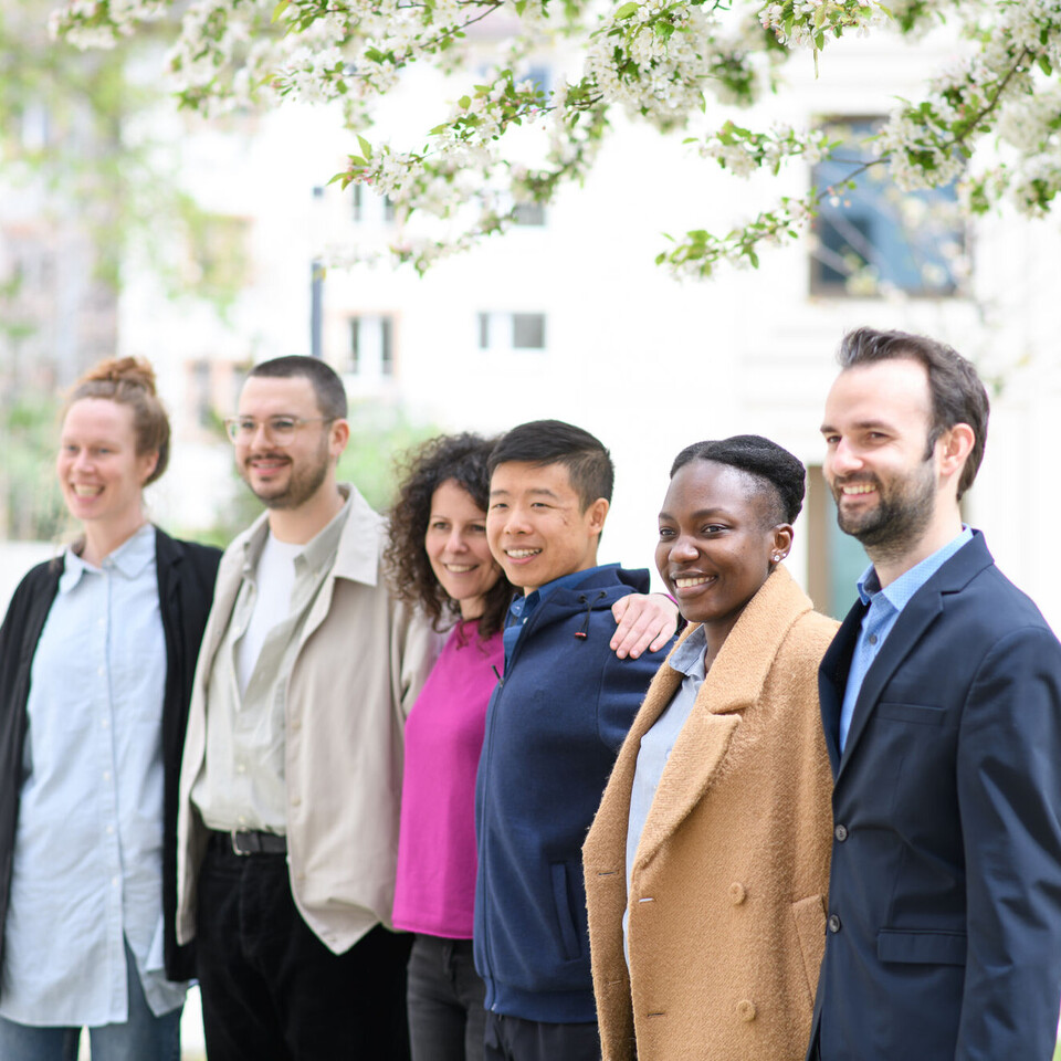 Gruppe von Mitarbeitenden die sich umarmen