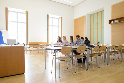 Sechs Studierende arbeiten in einem hellen Seminarraum