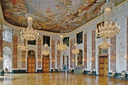 Prunkvoller Barocksaal im Mannheimer Schloss mit Kristalllüstern, Deckenfresken und vergoldeten Türen.