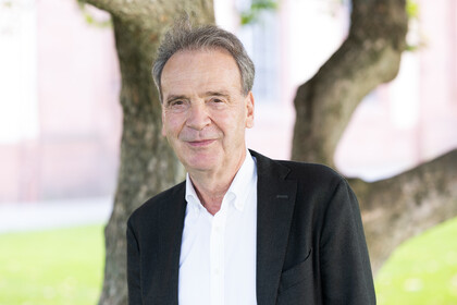 Prof. Stefan Reichelstein. Er lächelt und trägt einen schwarzen Anzug.