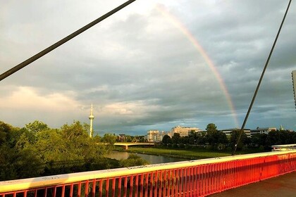 Blick auf eine Brücke über den Neckar. Im Hintegrund sieht man den Mannheimer Fernsehturm und oben am Himmel einen Regenbogen.