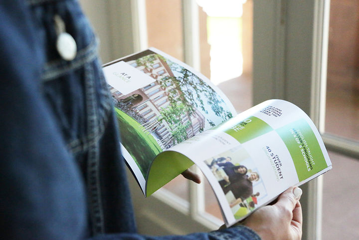Two hands hold an open brochure.