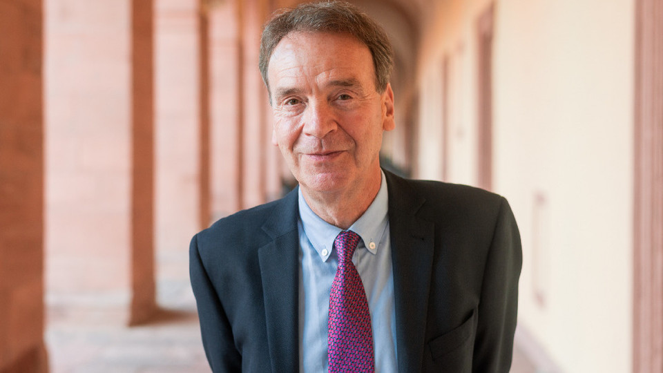 Prof. Reichelstein hat kurze Haare und trägt Anzug und Krawatte.