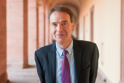 Prof. Reichelstein hat kurze Haare und trägt Anzug und Krawatte.