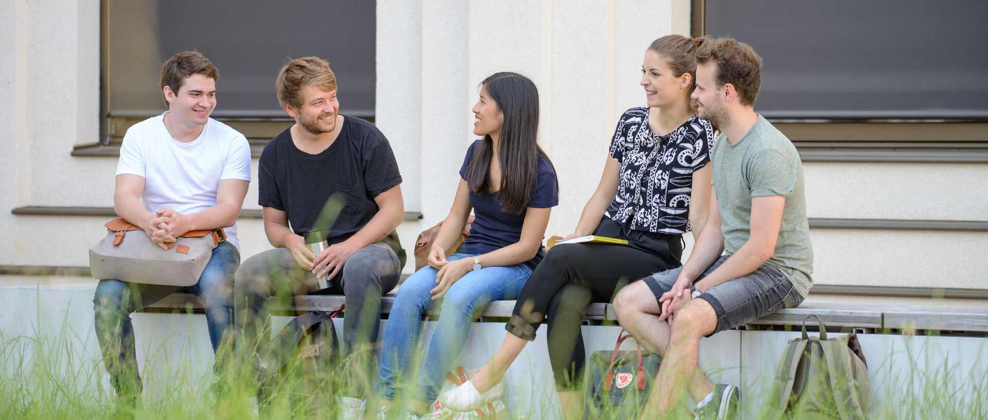 Students are sitting next to each other on a bench 