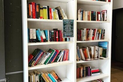 Blick auf das Büchertausch-Regal im Ostflügel beim Campus Shop.