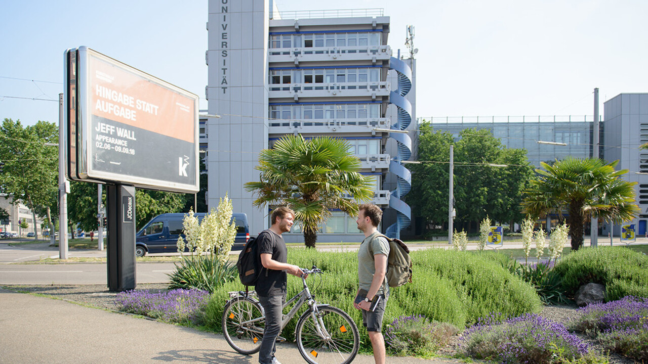 Zwei Studierende unterhalten sich vor dem A5-Gebäude.