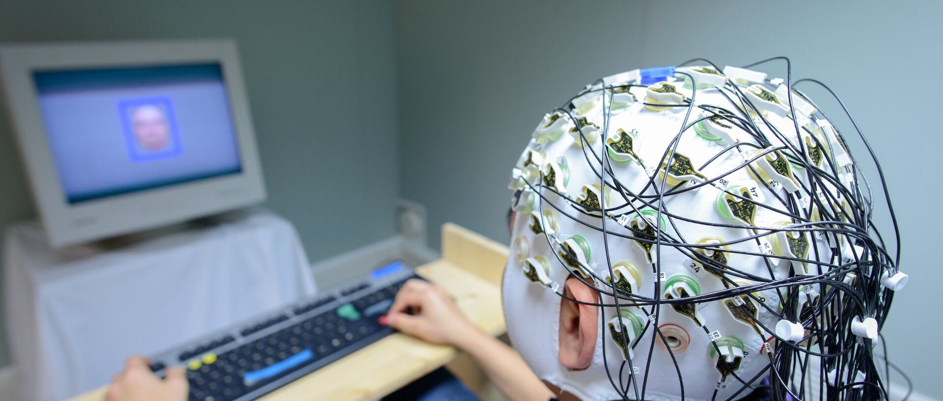 People sitting in front of a computer and wearing an instrument to measure brain waves