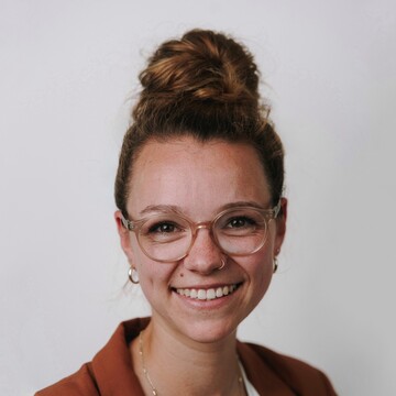 Priscilla Golling. Sie trägt einen rostroten Blazer vor einem neutralen Hintergrund