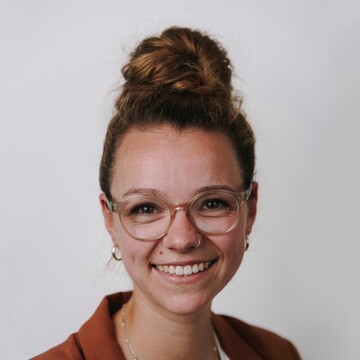 Priscilla Golling. Sie trägt einen rostroten Blazer vor einem neutralen Hintergrund