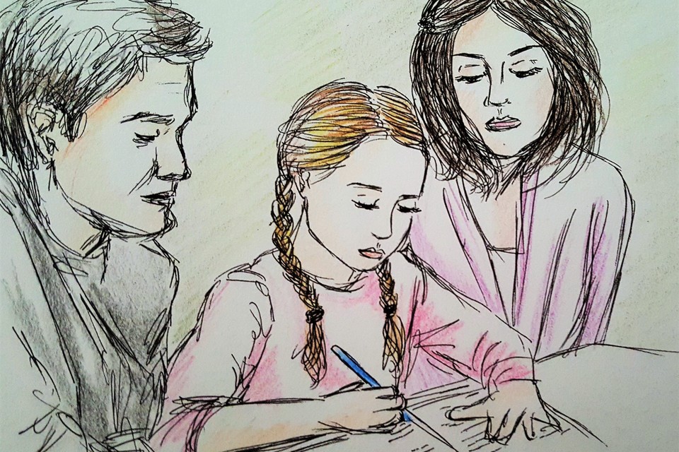 Zwei Erwachsene schauen über einem Mädchen über die Schulter, das in ein Heft schreibt.