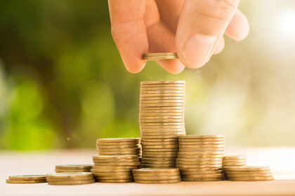 Eine Person stapelt Münzen aufeinander.