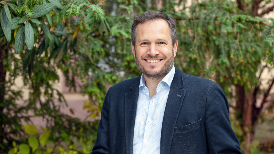 Lutz Pöhlmann. Er lacht und trägt ein dunkles Jackett.