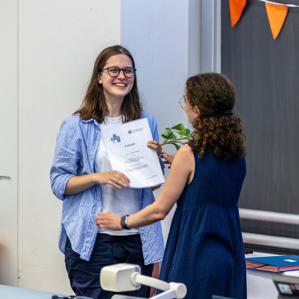 Studentin bekommt Urkunde überreicht
